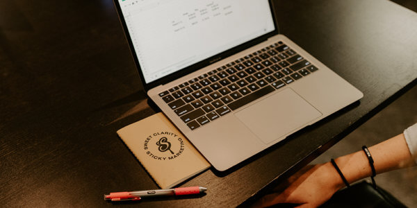 computer and Syrup notepad with hashtags