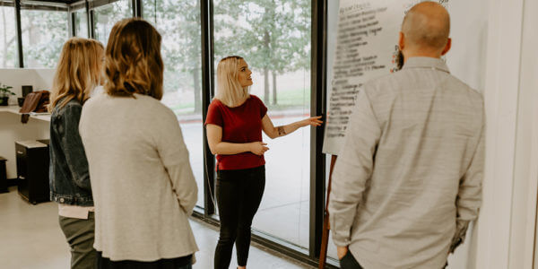Group of people at syrup talking through a debrief session, asking the right questions to get better