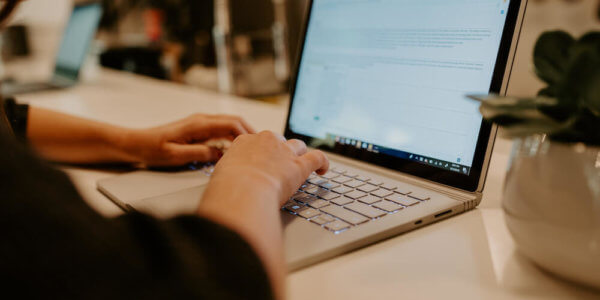 Girl typing on a computer, resending an email campaign