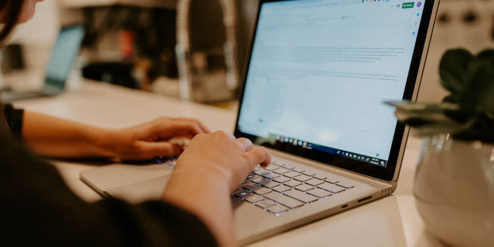 Woman typing on laptop working on email list cleaning