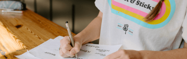 Designer drawing logo on sheet of paper - Branding agency visual identity work