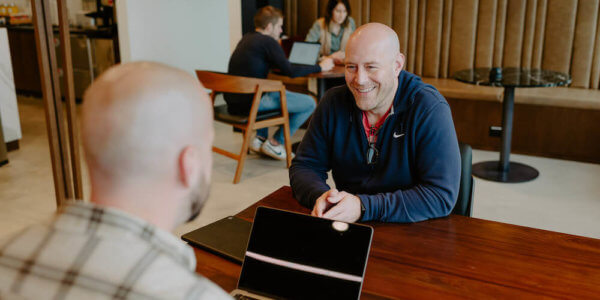 Jason smiling while talking to Syrup team member about engineering culture