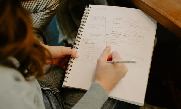 Girl writing notes in notebook on what a brand is built on