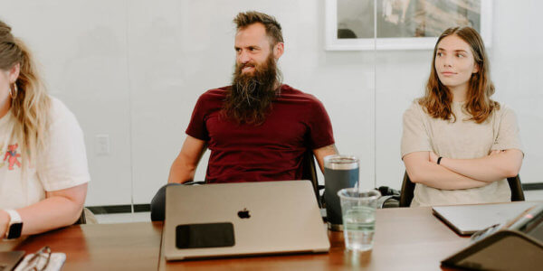 Benj sitting at a table with the Syrup team talking about the enemy of a great brand