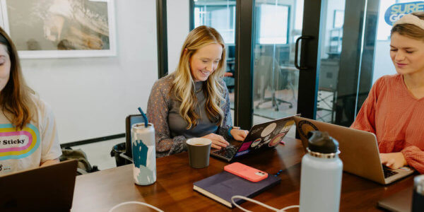 Kate, Syrup team member, typing on laptop at co-working desk space talking about who matters