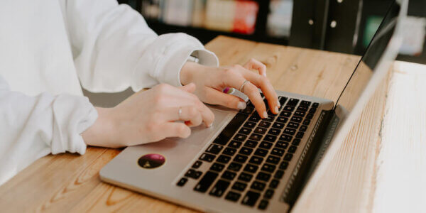 Girl typing on laptop computer about cold email marketing trends