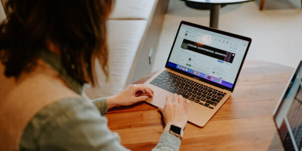 Woman typing on laptop computer showing consistent message on the screen (focus, confidence, growth)