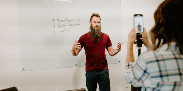 Benj standing in front of a whiteboard talking about marketing in a recession