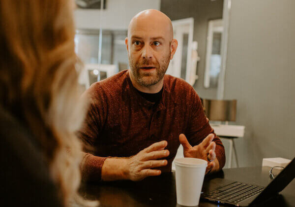 Jason talking to someone in a meeting about B2B Sales