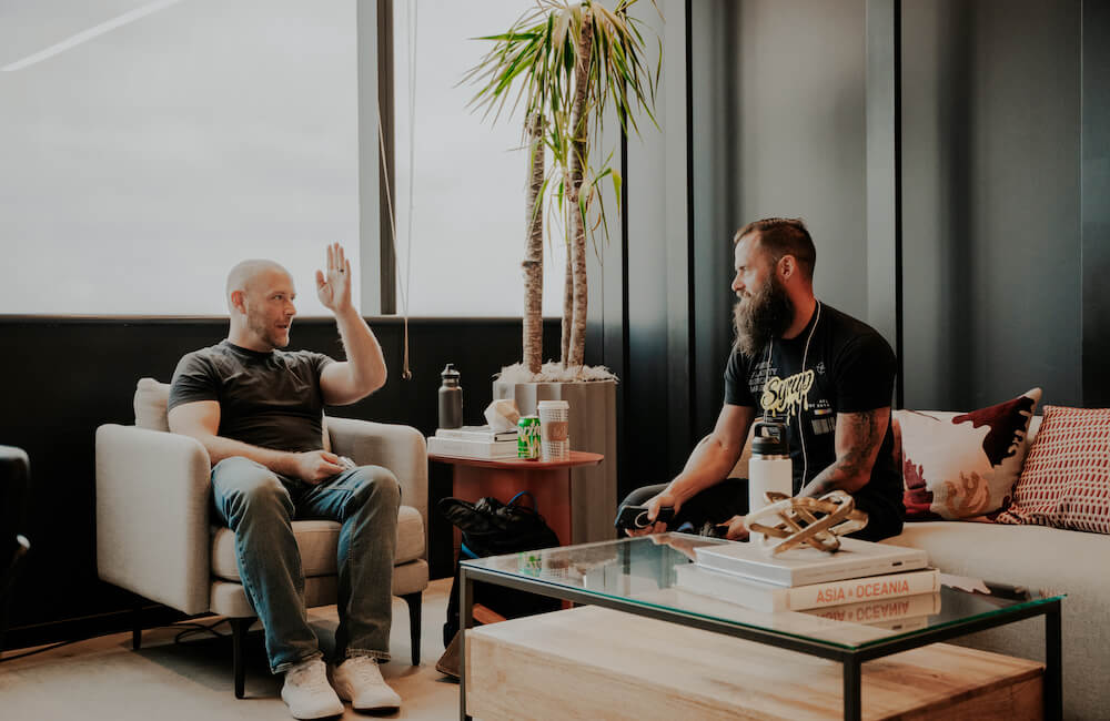Jason and Benj sitting on couches in the office discussing how to ask for referrals