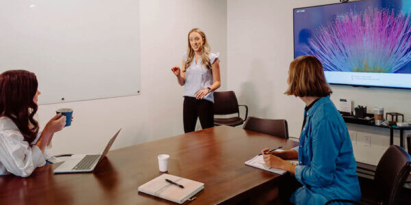 Kate talking in front of two members of the Syrup team