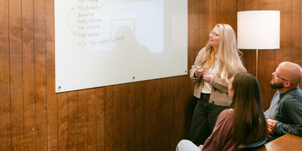 3 Syrup team members looking at a whiteboard trying to get inspired with creativity