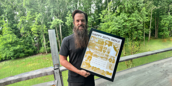 Benj holding up a frame that says Happy 20 yers, Benj!