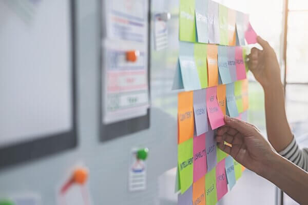Colorful sticky notes on a whiteboard showing b2b marketing strategy vs tactics