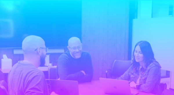 Team sitting around table discussing b2b content engine
