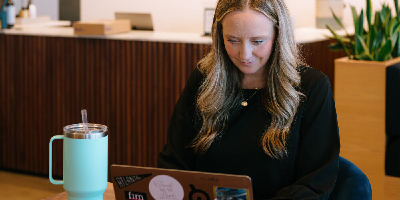 Kate typing on her laptop writing out the AI marketing budget