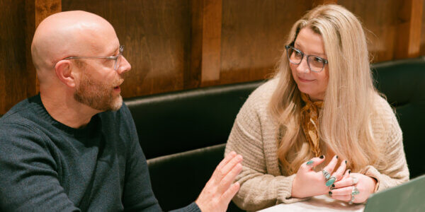 Jason and Paiton sitting at a table discussing AI visibility audit
