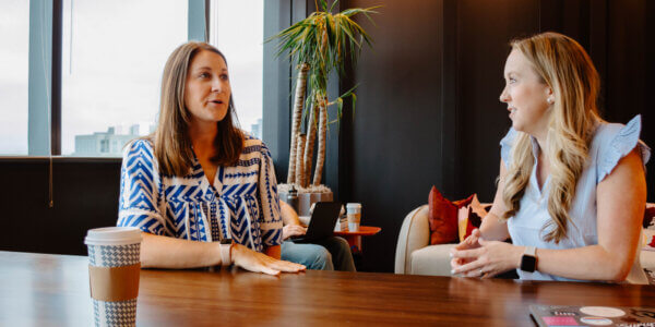 Kate and Morgan sitting at a table talking about trust as a revenue metric