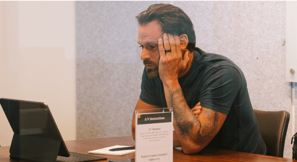 Man sitting down looking at his laptop with 2027 B2B Marketing Budget on screen